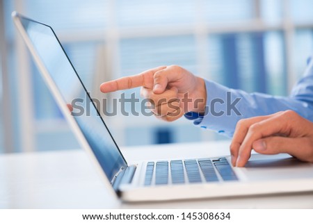 Close-up of a hand pointing something in the computer inside