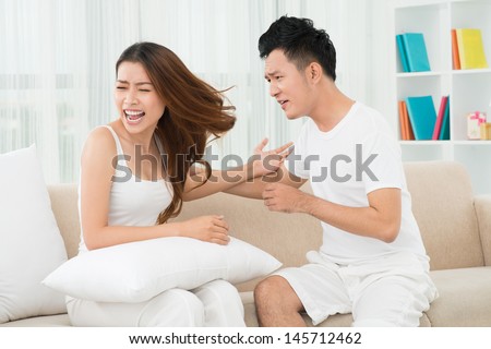 A young unhappy couple emotionally arguing at home