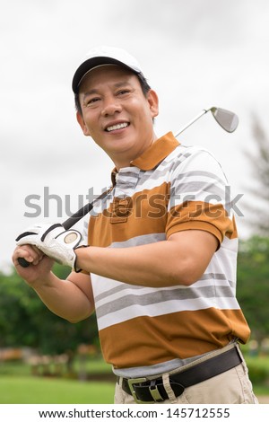 Vertical shot of a mature golfer ready to play outside
