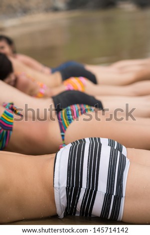Vertical image of funny youngsters sun tanning on the beach