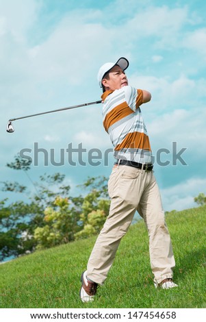 Full-length image of a man playing golf outside