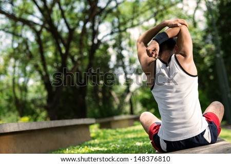 Copy-spaced image of a sporty person doing back stretching outside