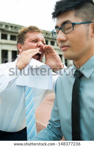 Vertical image of an emotional screaming businessman on the foreground