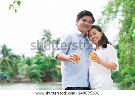Copy-spaced portrait of a mature couple in-love standing and posing at camera outside