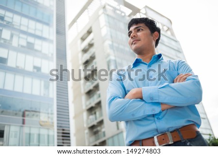 Image of a confident young man standing in the city with his arms crossed
