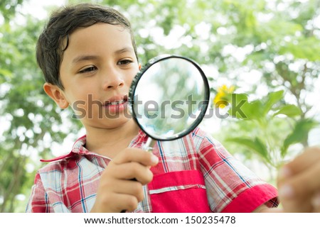Guy looking at the flower through the magnifying glass