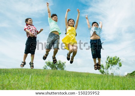 Bunch Of Kids Jumping In Excitement On The Meadow