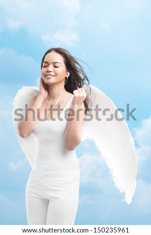 Vertical shot of a winged girl listening to music with pleasure