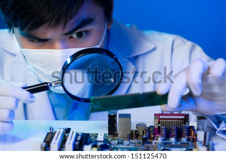 An electronic engineer analyzing the computer motherboard with the zoom on the foreground