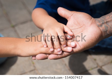 Close-up of a father\'s palm with his childrenÃ?Â¢??s hands on top