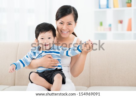Copy-spaced portrait of a cheerful mum with her little son at home