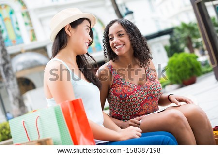 Copy-spaced image of young women talking after shopping outside