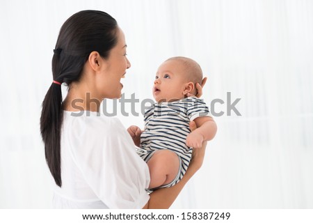 Copy-spaced image of an excited mother holding her son on hands over white