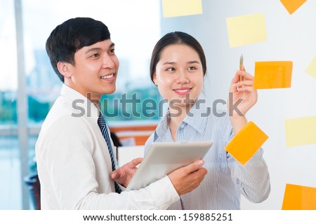 Image of business colleagues explaining business targets on the foreground