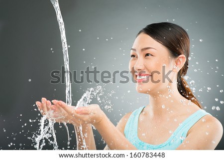 Isolated image of a woman smiling while water splashing in her hands