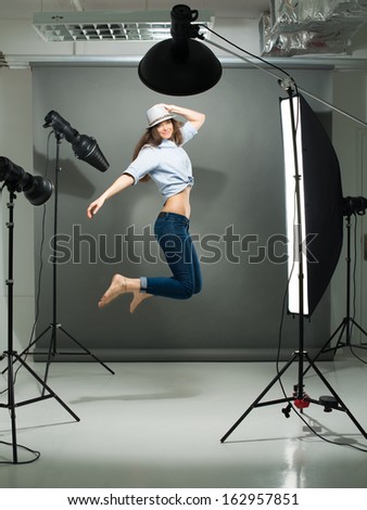 Portrait of a jumping model working in the professional photo studio