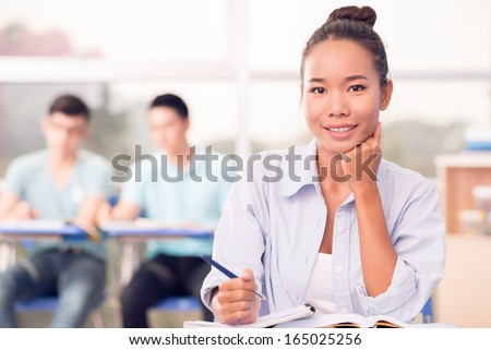 Portrait of a lovely modern student in the classroom on the foreground