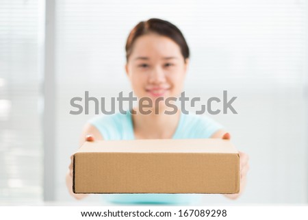 Close-up portrait of a girl holding a card box on the foreground