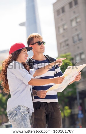 Close up image of a young couple lost in the city and finding the root using a map