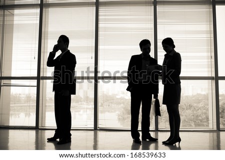 Image of business silhouettes standing at the office