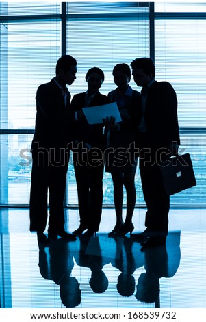 Vertical image of a blurry business team discussing the strategy