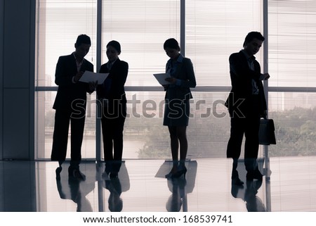 Image of business silhouettes standing at the office