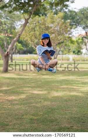 Girl floating in the air with a book