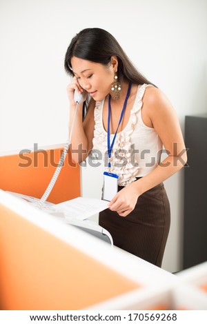 Office worker answering the call and printing documents