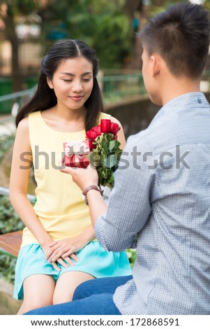 Boy giving flower and present to his girlfriend