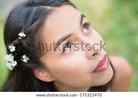 Close-up of a young attractive woman with daisy flowers in hair
