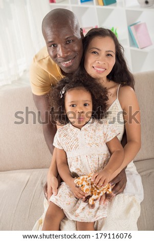 Vertical portrait of a mixed adorable family at home