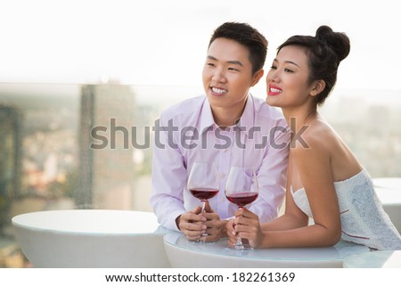 Close-up image of a young couple standing at a cafe and dreaming about their future