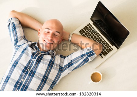 Above view of a businessman resting on the floor with smile after exhausted working day