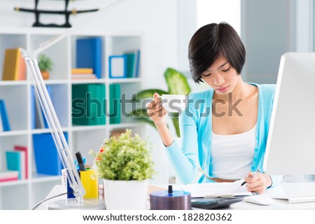 Businesswoman working with financial documents while having lunch