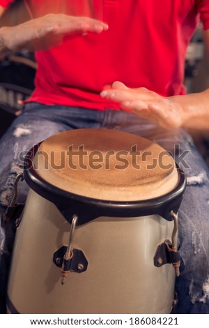 Man playing Cuban drum by his hands