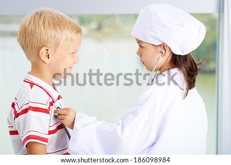 Little girl listening to heartbeat of a little boy
