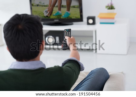 Man watching soccer game, view from the back