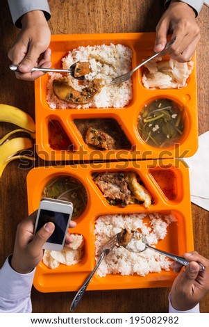Man texting while having lunch with his colleague, view from the top