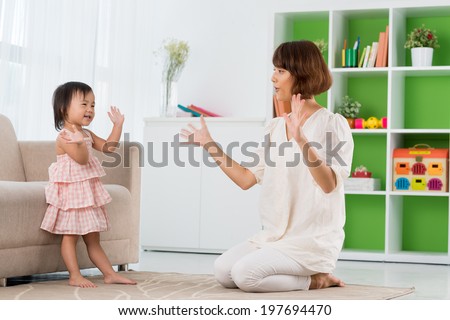 Chinese mother and daughter playing clapping game
