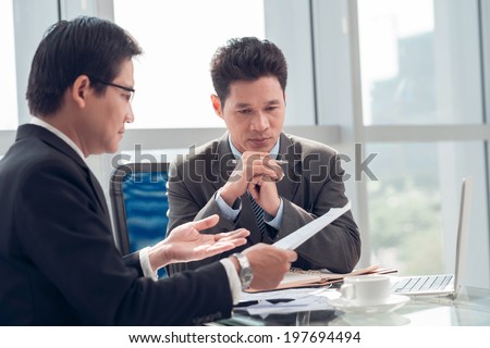 Two serious businessmen discussing project