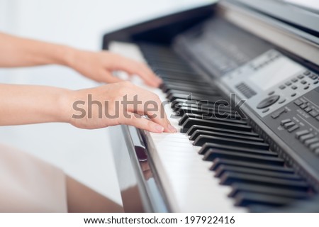 Female hands over piano, body and buttons of the piano were digitally modified