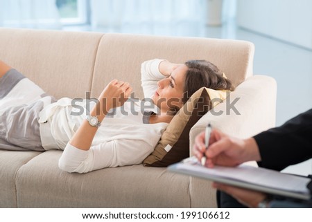 Sad woman lying on the bed in the office of psychiatrist