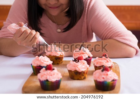Close-up of woman enjoying cooking cupcakes