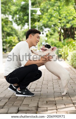 Happy man playing with his bulldog
