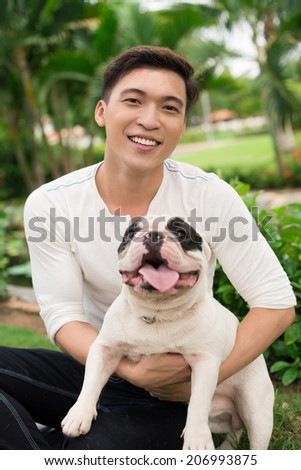 Smiling Asian man with a French bulldog