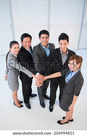 Office managers stacking their hands as a symbol of unity