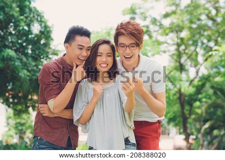 Laughing young people looking at the mobile phone