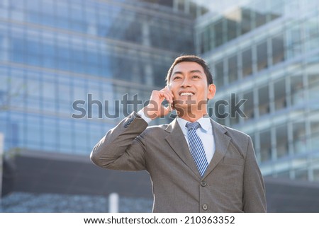 Portrait of Vietnamese businessman calling on the phone outdoors