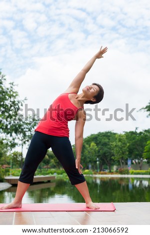 Senior sporty woman stretching doing stretching exercises outdoors