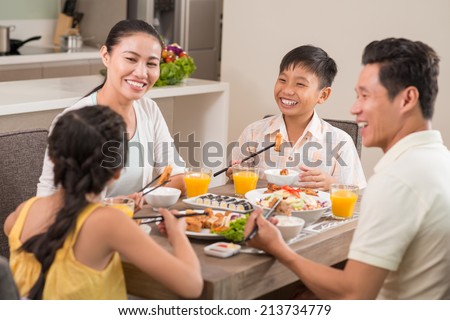 Happy Vietnamese family laughing while having dinner